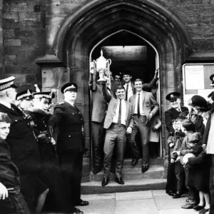 Ron Tatum carries the trophy as he and the members of the team leave the town hall Ron Tatum carries the trophy as he and the members of the team leave the town hall