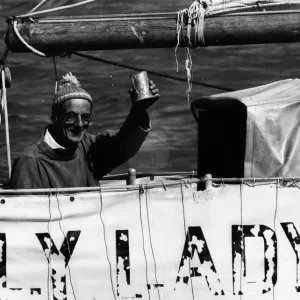 Il velista circumnavigatore Alec Rose solleva un bicchiere a bordo della sua barca Lively Lady.