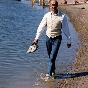 Roy Marsden actor walking along beach paddling in water