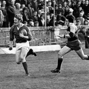 Roy Mathias, Llanelli Rugby Union Player, chased by Keith James of Newport Roy Mathias, Llanelli Rugby Union Player, chased by Keith James of Newport