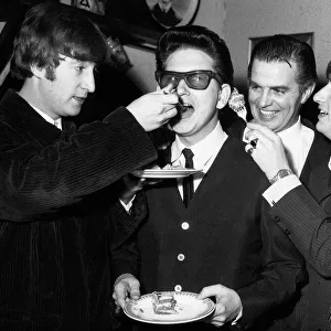 Roy Orbison being fed birthday cake by John Lennon while Ringo Starr looks