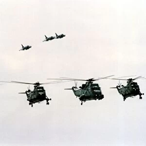 Four Royal Navy Sea King helicopters and three Sea Harriers in flight