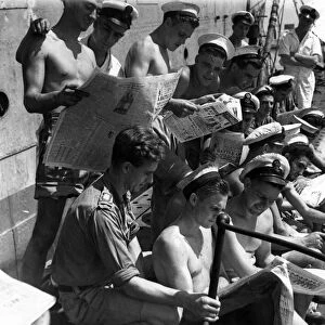 Royal Navy submariners in the Far East eagerly reading British Sunday newspapers