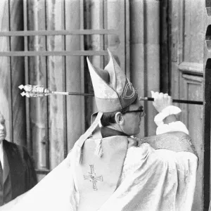 The Rt Revd Dr John Habgood the Bishop of Durham strikes the doors of the Cathedral with