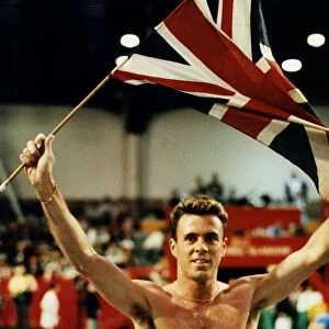 Runner Tom McKean holding up Union Jack in the Kelvin Hall after winning race athletics