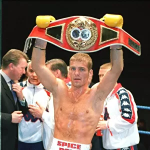 Ryan Rhodes Boxer standing in the ring holding belt celebrates after winning the IBF