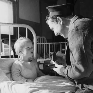 Sailor Gordon Davis of the Royal Navy repais the doll of a patient in the childrens ward