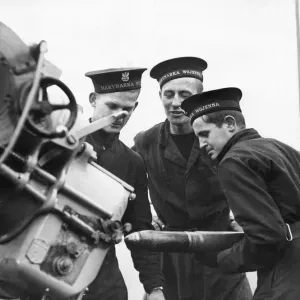 Three sailors manning a 3 inch anti-aircraft gun at gun practice on board the Polish Navy Three sailors manning a 3 inch anti-aircraft gun at gun practice on board the Polish Navy