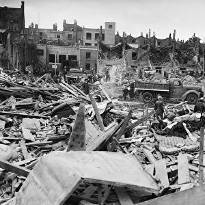 Salvage workers search through the debris follow a V1 Flying Bomb attack of Deptford
