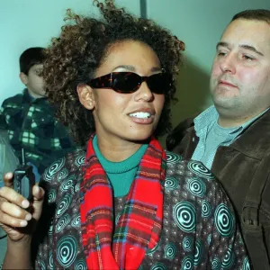 SCARY SPICE AT AIRPORT APRIL 1998 Spice Girls Mel B wearing a tartan scarf