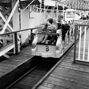Scenes in Margate, Kent, during Good Friday. A couple on a funfair ride. 27th March 1964 Scenes in Margate, Kent, during Good Friday. A couple on a funfair ride. 27th March 1964