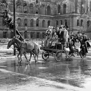 Scenes showing children being pulled along on a horse-drawn cart in the devastated German