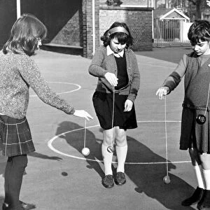 School children playing yoyo games in the school yard. March 1967