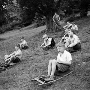 Schoolboys from West Wycombe go tobogganing on a hill in the village. circa 1945