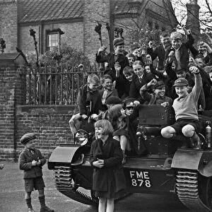 Schoolchildren clamber over a Bren Gun Carrier of the 2nd Battalion East Surrey Regiment