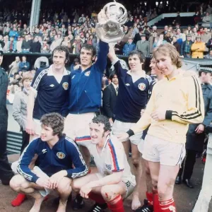 Schottischer Fußballspieler Joe Jordan hält die britische Internationale-Fußballsäule in der Luft mit Schottischer Fußballspieler Joe Jordan hält die britische Internationale-Fußballsäule in der Luft mit