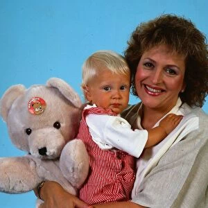 Scottish singer and actress Barbara Dickson holding her son and a teddy bear