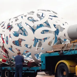 The sculpture Bottle of Notes is lifted off its low loader in the Central The sculpture Bottle of Notes is lifted off its low loader in the Central