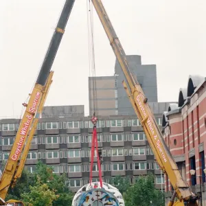 The sculpture Bottle of Notes is lifted off its low loader in the Central The sculpture Bottle of Notes is lifted off its low loader in the Central