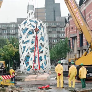 The sculpture Bottle of Notes is lifted off its low loader in the Central The sculpture Bottle of Notes is lifted off its low loader in the Central