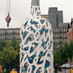 The sculpture Bottle of Notes is lifted off its low loader in the Central The sculpture Bottle of Notes is lifted off its low loader in the Central