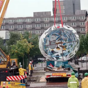 The sculpture Bottle of Notes is lifted off its low loader in the Central The sculpture Bottle of Notes is lifted off its low loader in the Central