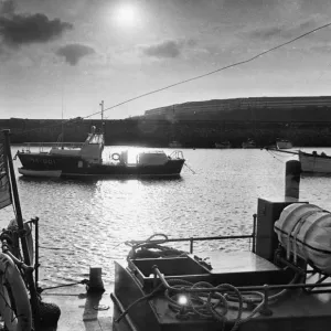 The sea is pool-placid as the sun goes down and the Barry lifeboat stands at her harbour The sea is pool-placid as the sun goes down and the Barry lifeboat stands at her harbour