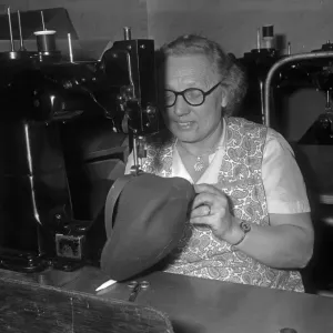 Seamstress sewing the inner band into a flat cap at the Denham and Hargreaves factory Seamstress sewing the inner band into a flat cap at the Denham and Hargreaves factory