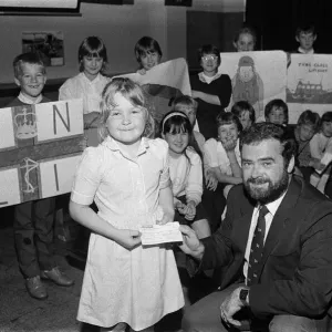 Una niña de siete años, Adele Brooke, presenta un cheque de £588 del Dalton Junior School a Mr.