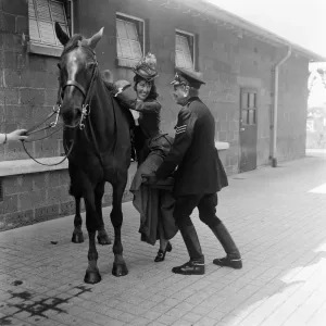 Black and white photograph print of a man assisting a woman onto her horse Black and white photograph print of a man assisting a woman onto her horse