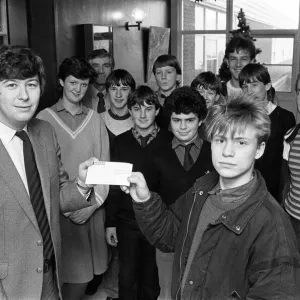 Étudiants de Shelley High School et sixième forme présentent un chèque de 115 livres sterling à Graeme Staniforth pour l'appel d'urgence des bébés en danger le 23 décembre 1985.