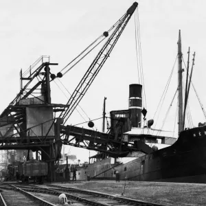 A ship loading anthracite coal by conveyor at the Swansea docks. Circa January 1937