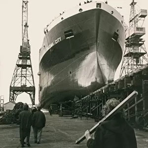 Shipyard Workers watch the launch of the Tocoma City as the new liner glides from her
