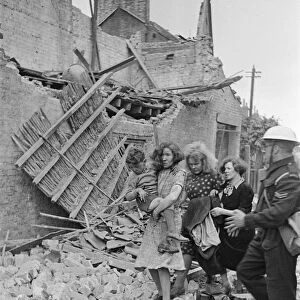 Shock on the faces of a family as they are assisted by an ARP warden after a raid, 1940
