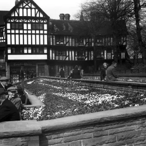 Shoppers enjoy the spring sunshine and the flower beds outside Timothy Whites in Trinity