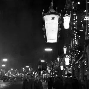 Shoppers walk underneath hanging illuminations on Regent Street after the Christmas
