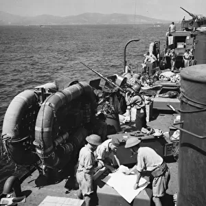 Within sight of the coast of France R. A. F. airmen study a map map at sea during Second