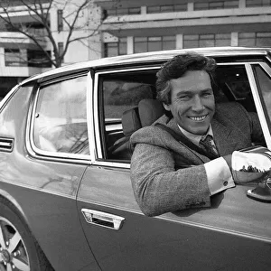 Simon Dutton Actor leans out of the window of an Aston Martin DBS March 1989