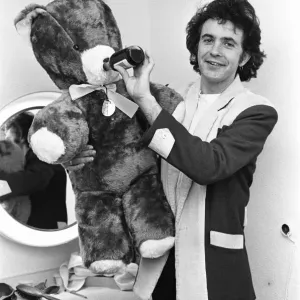 Singer and Actor David Essex poses with a teddy bear sent to him by a fan before going