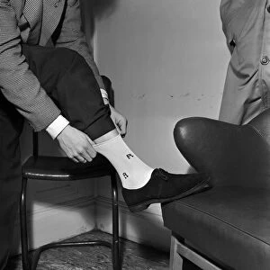 Singer and actor Tommy Steele showing off his Rock n Roll socks