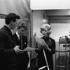Singer and actress Kathy Kirby in the recording studio discussing musical score with two