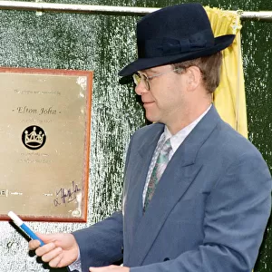 Singer Elton John unveils a plaque to mark the start of work on the AIDS clinic centre at