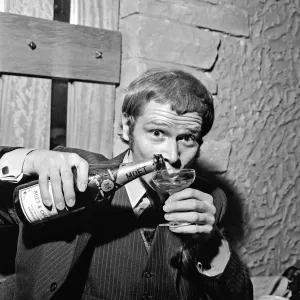 Singer Long John Baldry celebrates doing to the top of the charts with a bottle of Singer Long John Baldry celebrates doing to the top of the charts with a bottle of