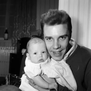 Singer Marty Wilde at home in Chiswick with his baby daughter Kim. 30th January 1961