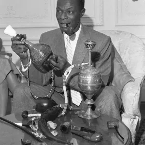 Singer and pipe collector Nat King Cole seen here with his collection of pipes in his Singer and pipe collector Nat King Cole seen here with his collection of pipes in his