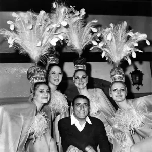 Singer Tony Bennett. poses with the Doriss Girls from the Moulin Rouge in Paris