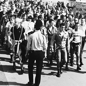 Skinheads being marched back to the railway station at Southend Essex where a strong