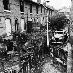 Viviendas en barrios marginales de Birmingham. Coche quemado en el pasaje detrás de casas abandonadas. Viviendas en barrios marginales de Birmingham. Coche quemado en el pasaje detrás de casas abandonadas.