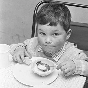 A small boy enjoying his jelly and ice cream during the Birch Copse School Christmas