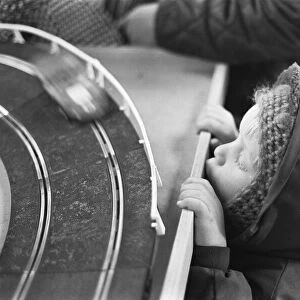 Small boy looks on longingly at the latest Scalextric slot car racing set in the toy